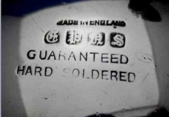 EPNS silver plate mark — close-up photograph of the letters E, P, N, S punched into a silver-plated piece, showing the standard cartouche layout used across British silverware