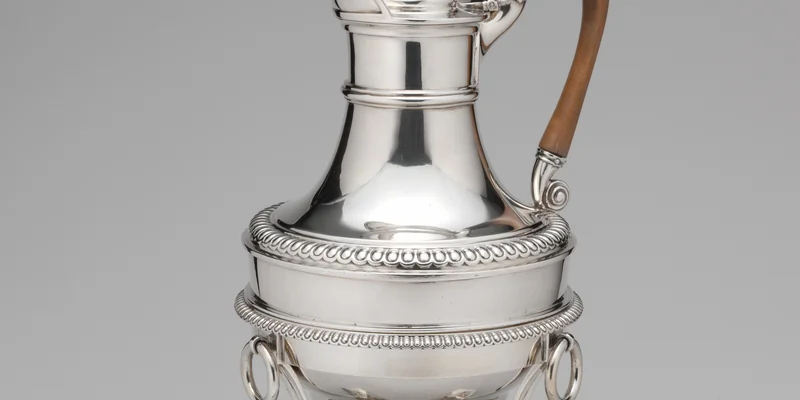 Regency-era Paul Storr silver hot water jug (London, 1807–8) — shoulder detail showing Georgian gadroon banding, ornate turned finial and boxwood scroll handle. Metropolitan Museum of Art