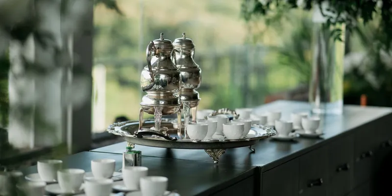 An elegant antique silver tea service with kettles and cups on a tray